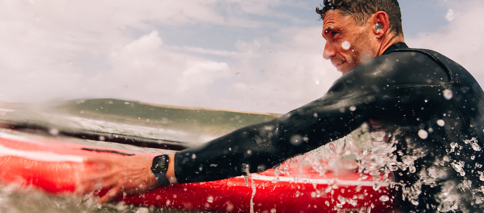 Surfeur en combinaison émergeant de l'eau